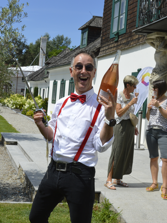 Der Kellner am Sommerfest 2023 köpft gerade eine Flasche Sekt mit einem Säbel | © MVH